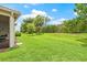 Expansive backyard with lush green lawn and various trees, providing a serene outdoor space at 4911 Rock Island Ct, Wimauma, FL 33598