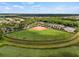 An aerial view of a well-maintained baseball field with green grass and ample parking at 4911 Rock Island Ct, Wimauma, FL 33598