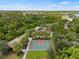An aerial view of a basketball court with a vegetable garden, picnic area, and mature trees at 4911 Rock Island Ct, Wimauma, FL 33598