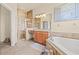 Well-lit bathroom featuring a tub, glass-enclosed shower, and granite countertop vanity at 4911 Rock Island Ct, Wimauma, FL 33598
