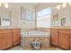 The primary bathroom features double sinks, a large window, and a soaking tub at 4911 Rock Island Ct, Wimauma, FL 33598