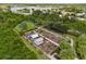 An aerial view of a fenced community garden with a shed and well-tended plots near a lake at 4911 Rock Island Ct, Wimauma, FL 33598
