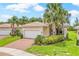 A lovely single-story home with a tile roof, brick driveway, and beautifully landscaped front yard at 4911 Rock Island Ct, Wimauma, FL 33598
