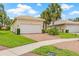 Well-maintained home featuring a two-car garage, brick driveway, and manicured landscaping at 4911 Rock Island Ct, Wimauma, FL 33598