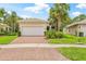 A lovely single-story home with a tile roof, brick driveway, and beautifully landscaped front yard at 4911 Rock Island Ct, Wimauma, FL 33598