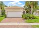 Charming single-story home featuring a brick driveway, two-car garage and tropical landscaping at 4911 Rock Island Ct, Wimauma, FL 33598