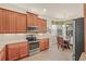 Well-equipped kitchen featuring wooden cabinets, stainless steel appliances, and granite countertops at 4911 Rock Island Ct, Wimauma, FL 33598