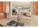 Granite counters with stainless sink overlooking dining and living areas at 4911 Rock Island Ct, Wimauma, FL 33598