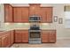 Modern kitchen with stainless steel appliances, granite countertops, and wooden cabinetry at 4911 Rock Island Ct, Wimauma, FL 33598