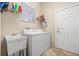 Functional laundry room with washer, dryer, utility sink, shelving, and access door at 4911 Rock Island Ct, Wimauma, FL 33598