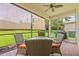 Comfortable screened patio with brick flooring, ceiling fan, and outdoor dining set at 4911 Rock Island Ct, Wimauma, FL 33598