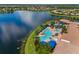 An aerial view of the community pool with lounge chairs, a hot tub and wading pool next to a lake at 4911 Rock Island Ct, Wimauma, FL 33598