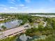 Aerial view of a decorative water feature and bridge entering the community by a lake with fountains at 4911 Rock Island Ct, Wimauma, FL 33598