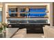 Modern home bar featuring floating shelves, black marble countertop, and a sink with black cabinets at 501 Barcelona Dr, Tierra Verde, FL 33715