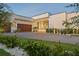 Modern home with beautiful landscaping, a paver driveway, and wood-look garage door at 501 Barcelona Dr, Tierra Verde, FL 33715