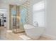 Elegant main bathroom with a modern tub, glass shower, and access to walk-in closet at 501 Barcelona Dr, Tierra Verde, FL 33715