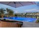Backyard infinity pool overlooking the bay with lounge chairs, umbrella, and beautiful waterfront views at 501 Barcelona Dr, Tierra Verde, FL 33715