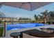 Backyard infinity pool overlooking the bay with lounge chairs, umbrella, and beautiful waterfront views at 501 Barcelona Dr, Tierra Verde, FL 33715
