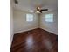 Bedroom with wood-look flooring, ceiling fan, two windows, and neutral paint at 5025 Tammy Ln, Holiday, FL 34690