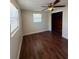 Bedroom featuring wood-look flooring, closet, ceiling fan, and lots of natural light at 5025 Tammy Ln, Holiday, FL 34690