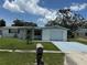 Charming single-story home with a white brick facade and a well-manicured lawn at 5025 Tammy Ln, Holiday, FL 34690