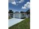 Single-story home with a white brick facade, attached garage, and a blue driveway at 5025 Tammy Ln, Holiday, FL 34690