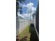Sideyard view with an AC unit, grass and a tall white fence at 5025 Tammy Ln, Holiday, FL 34690