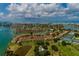 Scenic aerial view of waterfront property with tennis courts, lush greenery, and serene coastal surroundings at 505 Sandy Hook Rd # 505, Treasure Island, FL 33706