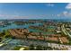 Beautiful aerial shot showcases waterfront property, tennis courts, and manicured green spaces in a vibrant coastal setting at 505 Sandy Hook Rd # 505, Treasure Island, FL 33706