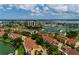 Aerial view of a residential neighborhood with waterfront access, lush landscaping, and views of the city skyline at 505 Sandy Hook Rd # 505, Treasure Island, FL 33706