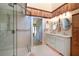 Stylish bathroom featuring a glass enclosed shower and dual sinks, accented with wood details at 505 Sandy Hook Rd # 505, Treasure Island, FL 33706