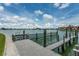 Picturesque dock view showcasing waterfront living under a partly cloudy sky at 505 Sandy Hook Rd # 505, Treasure Island, FL 33706