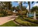 Welcoming entrance to Village at Paradise Island with lush landscaping and brick paved road at 505 Sandy Hook Rd # 505, Treasure Island, FL 33706