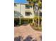 View of a townhouse featuring a well-maintained exterior, a private garage, and lush landscaping at 505 Sandy Hook Rd # 505, Treasure Island, FL 33706