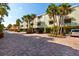 Exterior view of condo building with brick-paved parking and well-manicured landscaping at 505 Sandy Hook Rd # 505, Treasure Island, FL 33706