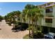 Well-maintained condo exterior with a private garage, lush palm trees, and brick paved driveway at 505 Sandy Hook Rd # 505, Treasure Island, FL 33706