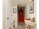 A bright entrance hall with tiled floors, wood stairs, and decorative wall art at 505 Sandy Hook Rd # 505, Treasure Island, FL 33706