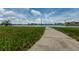 A calming view of the community lawn with a pathway leading to scenic waterfront views and bright blue skies at 505 Sandy Hook Rd # 505, Treasure Island, FL 33706