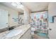 Well-lit bathroom featuring a granite vanity and a shower with coastal-themed curtains at 5065 Royal Palms Way # 303, New Port Richey, FL 34652
