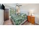 Cozy bedroom featuring wood-look floors, large windows, and tropical bedding at 5065 Royal Palms Way # 303, New Port Richey, FL 34652