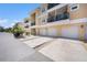 Three-story condo building with attached garages, driveways, and balconies on a sunny day at 5065 Royal Palms Way # 303, New Port Richey, FL 34652
