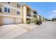 Three-story condo building with attached garages and balconies with well-maintained landscaping at 5065 Royal Palms Way # 303, New Port Richey, FL 34652
