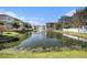 Scenic pond view with a fountain and residential buildings in the background, showcasing the community's landscaping at 5065 Royal Palms Way # 303, New Port Richey, FL 34652