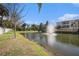 Community pond with a fountain, surrounded by lush landscaping and residential buildings, offering a serene view at 5065 Royal Palms Way # 303, New Port Richey, FL 34652