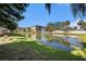 Beautiful community pond with a fountain, green lawn, and palm trees, surrounded by residential buildings at 5065 Royal Palms Way # 303, New Port Richey, FL 34652