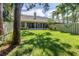 Expansive backyard featuring lush green lawn, mature trees, and screened patio at 5090 White Pine Ne Cir, St Petersburg, FL 33702