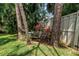 Bench seat in backyard among palms and other foliage near fence line at 5090 White Pine Ne Cir, St Petersburg, FL 33702