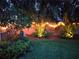 A charming backyard featuring a well-maintained lawn, lush plants, and ambient lighting, creating a serene outdoor space at 5090 White Pine Ne Cir, St Petersburg, FL 33702