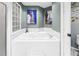 Bathroom featuring large white tub and glass block window at 5090 White Pine Ne Cir, St Petersburg, FL 33702