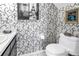 Decorated bathroom features a toilet, sink, and stylish black and white Paris themed wallpaper at 5090 White Pine Ne Cir, St Petersburg, FL 33702
